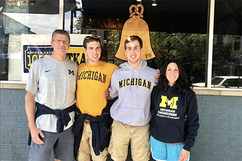 family photo of four in Michigan clothes outside the Pretzel Bell restaurant